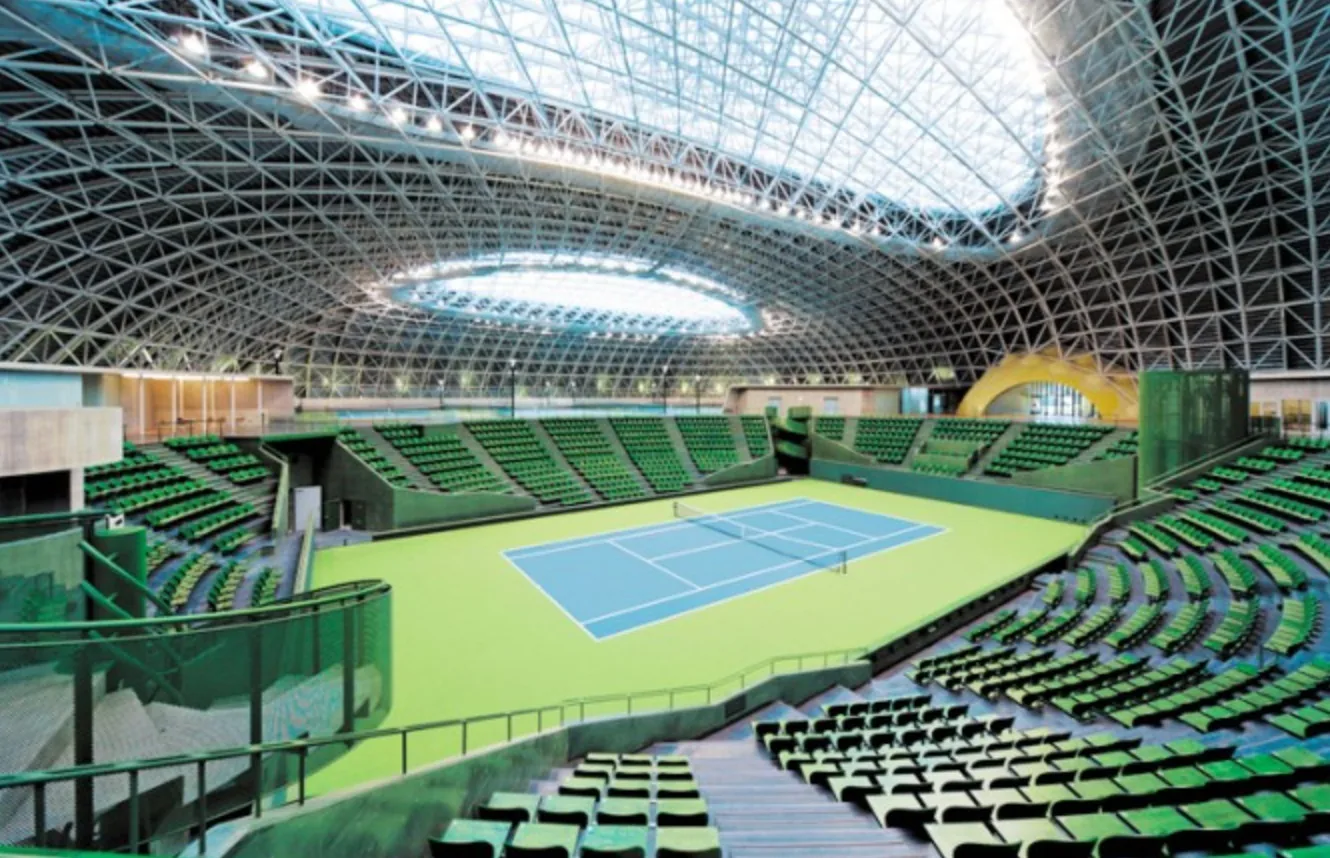 Inside the Bourbon Beans Dome: the centre court and its green stands under the steel lattice roof, with practice courts beyond